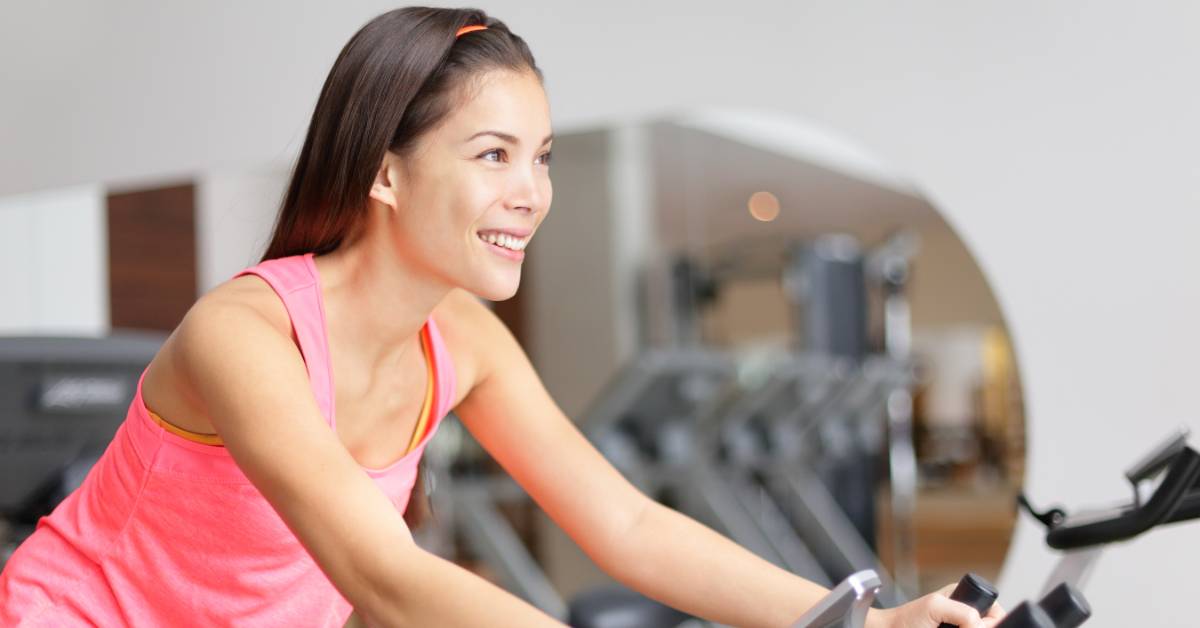 An image of a woman riding a spin bike.